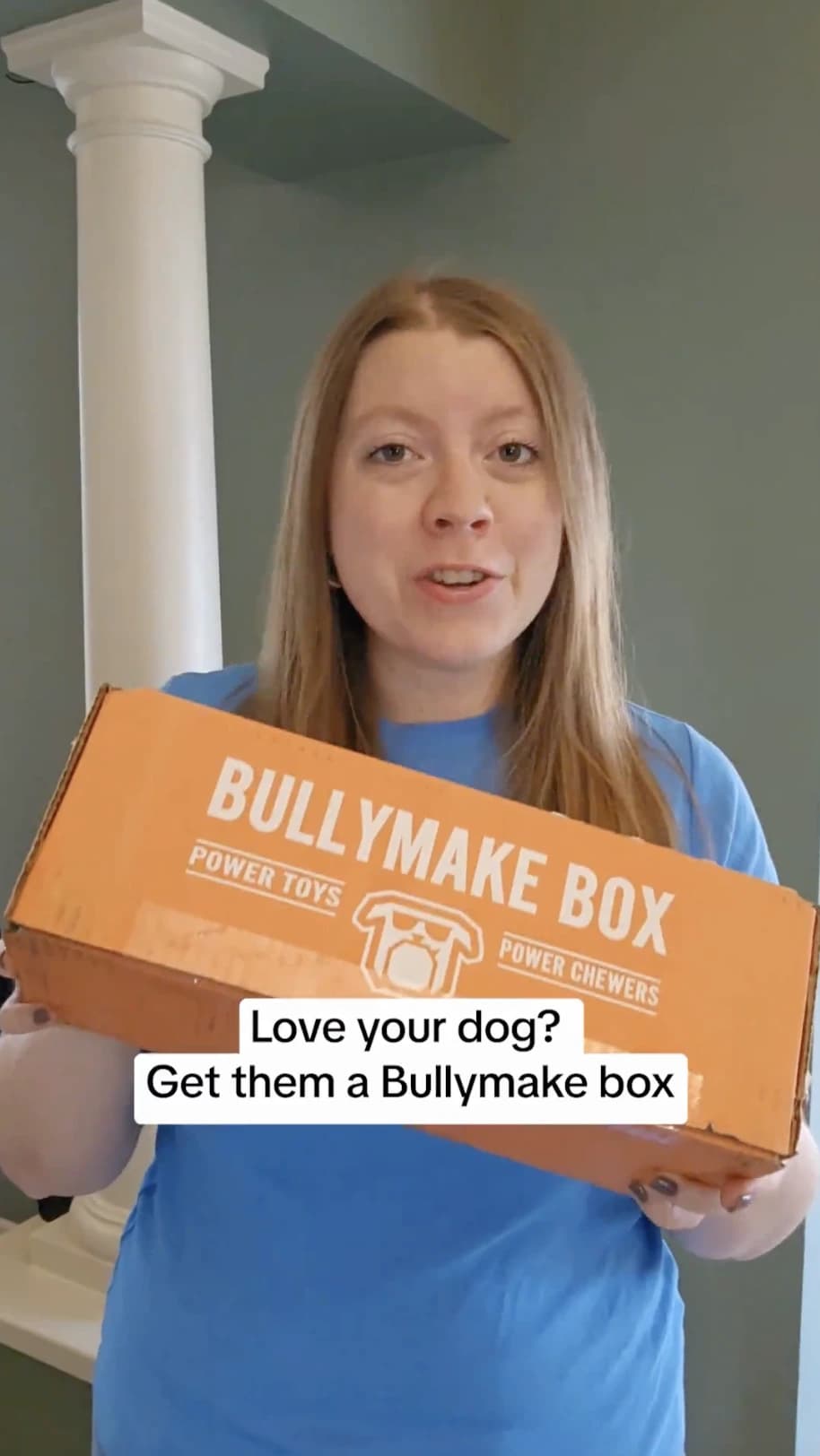 UGC creator holding a subscription box for her dog while talking to camera