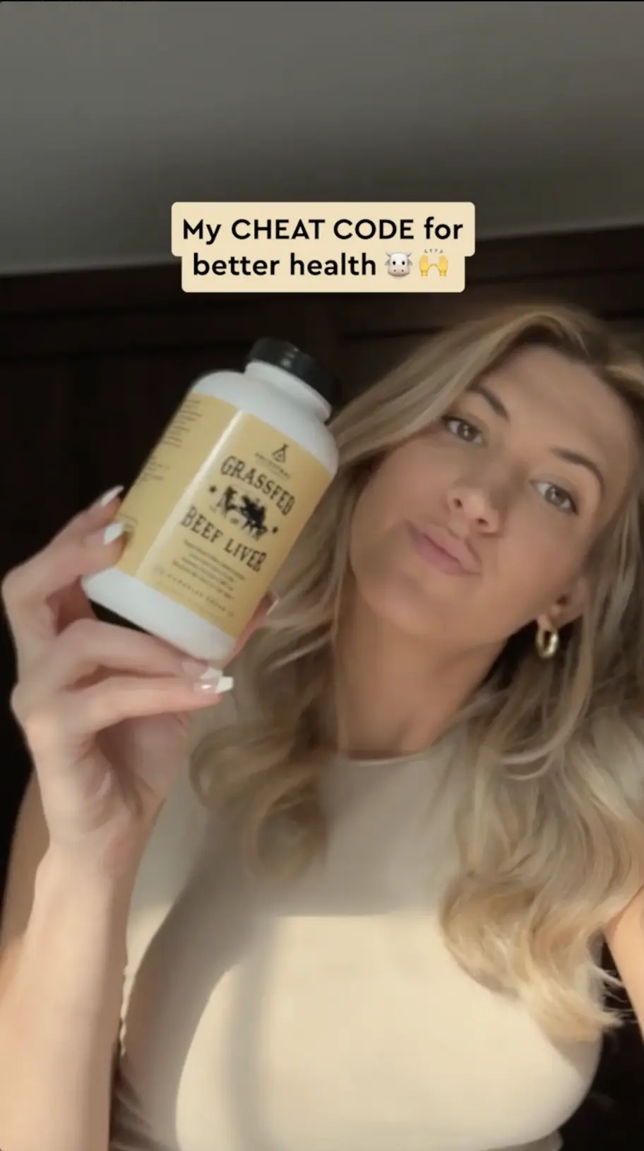UGC creator holding a supplement bottle up to her phone camera